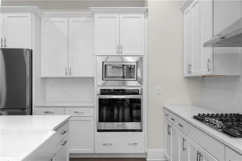 a kitchen with stainless steel appliances white cabinets and a stove