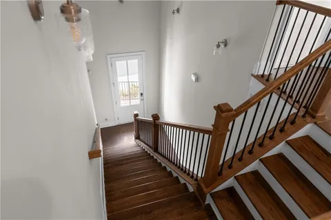 a view of a hallway with wooden floor and staircase