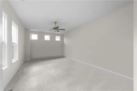 en empty room with windows and chandelier fan