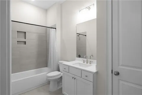 a bathroom with a bathtub shower sink vanity and toilet