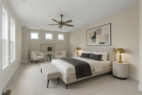 a bedroom with a bed couch chandelier and a window