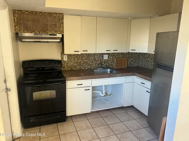 a kitchen with white cabinets and appliances