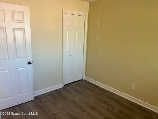 an empty room with wooden floor and closet