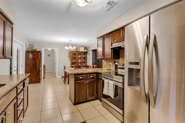 a kitchen with stainless steel appliances granite countertop a refrigerator and a stove top oven