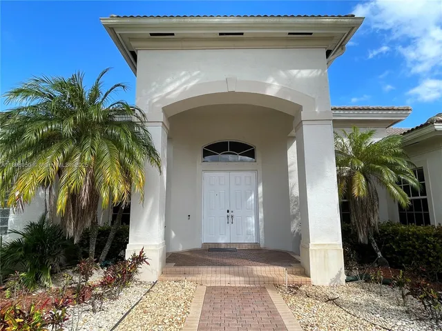 a front view of a house with plants