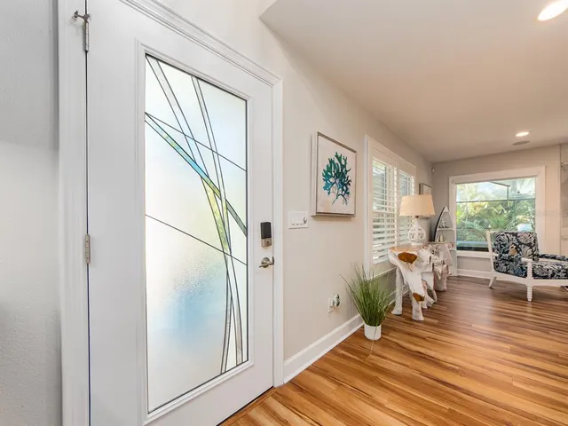 a living room with furniture and painting on the wall with wooden floor