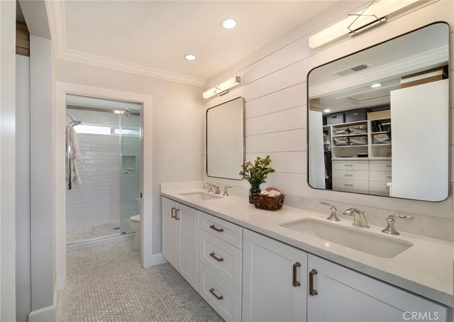 a bathroom with double sink and a mirror