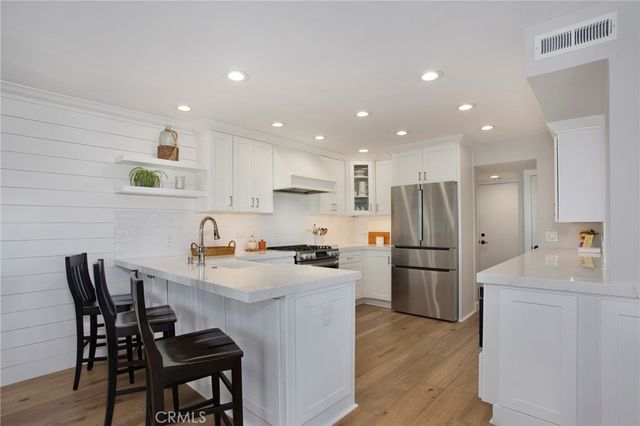 a kitchen with refrigerator and chairs