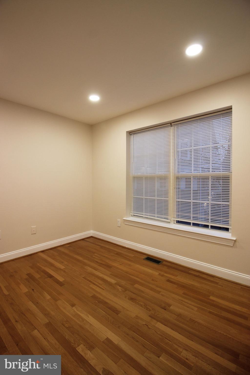 141 Chevy Chase Street, Unit 141 Gaithersburg, MD 20878 - Photo 18 of 32 an empty room with wooden floor and windows