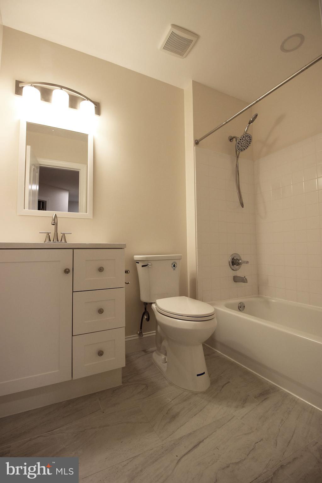 141 Chevy Chase Street, Unit 141 Gaithersburg, MD 20878 - Photo 19 of 32 a bathroom with a toilet a sink a mirror and bathtub