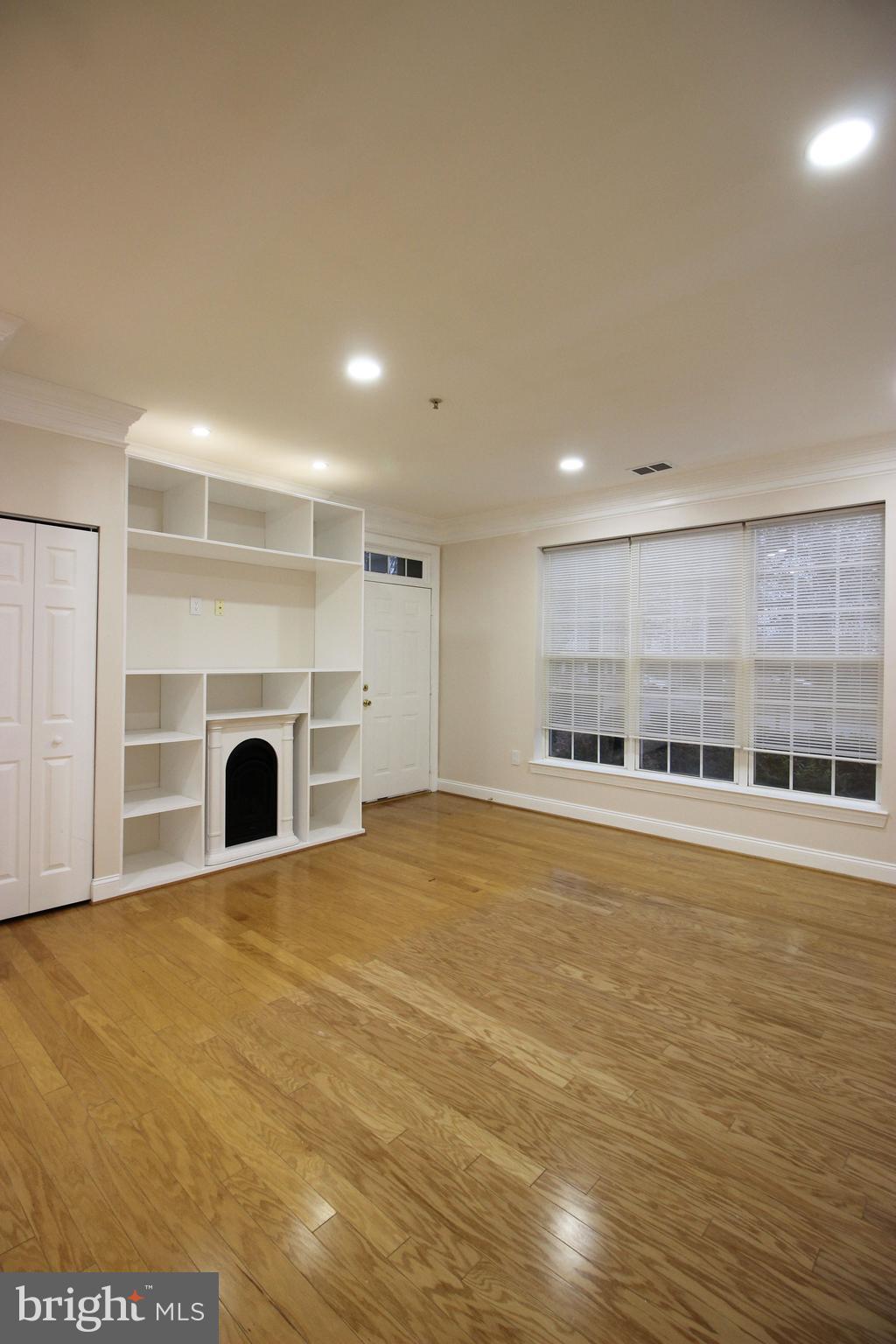 141 Chevy Chase Street, Unit 141 Gaithersburg, MD 20878 - Photo 2 of 32 a view of an empty room with wooden floor and a fireplace