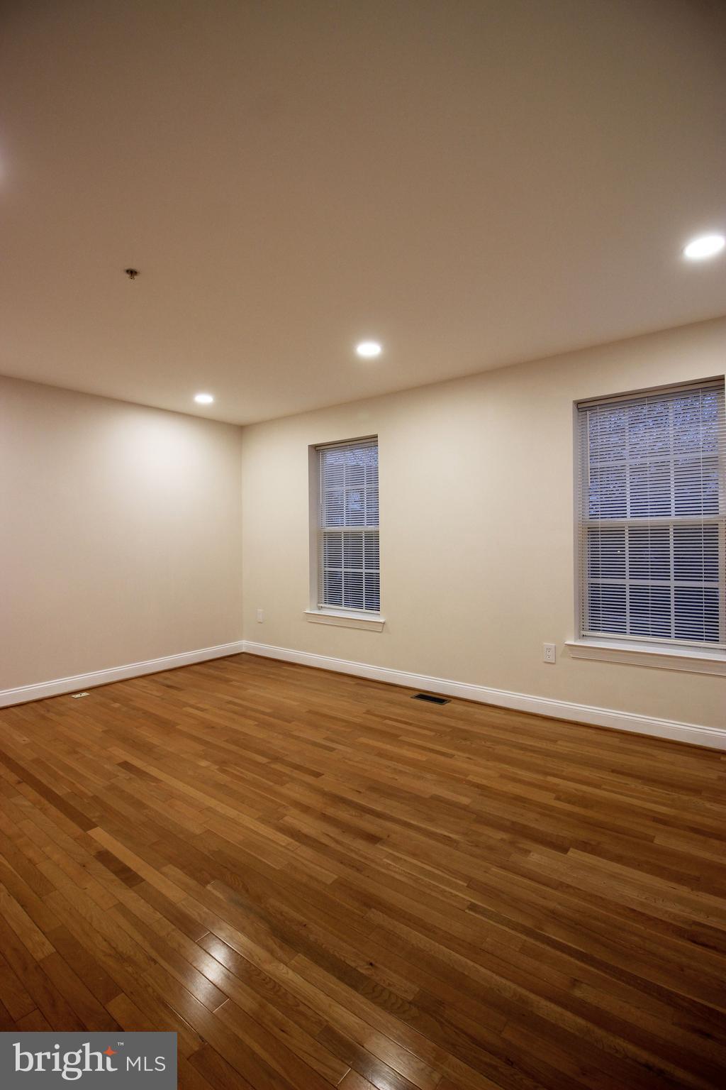 141 Chevy Chase Street, Unit 141 Gaithersburg, MD 20878 - Photo 23 of 32 a view of an empty room with wooden floor and a window