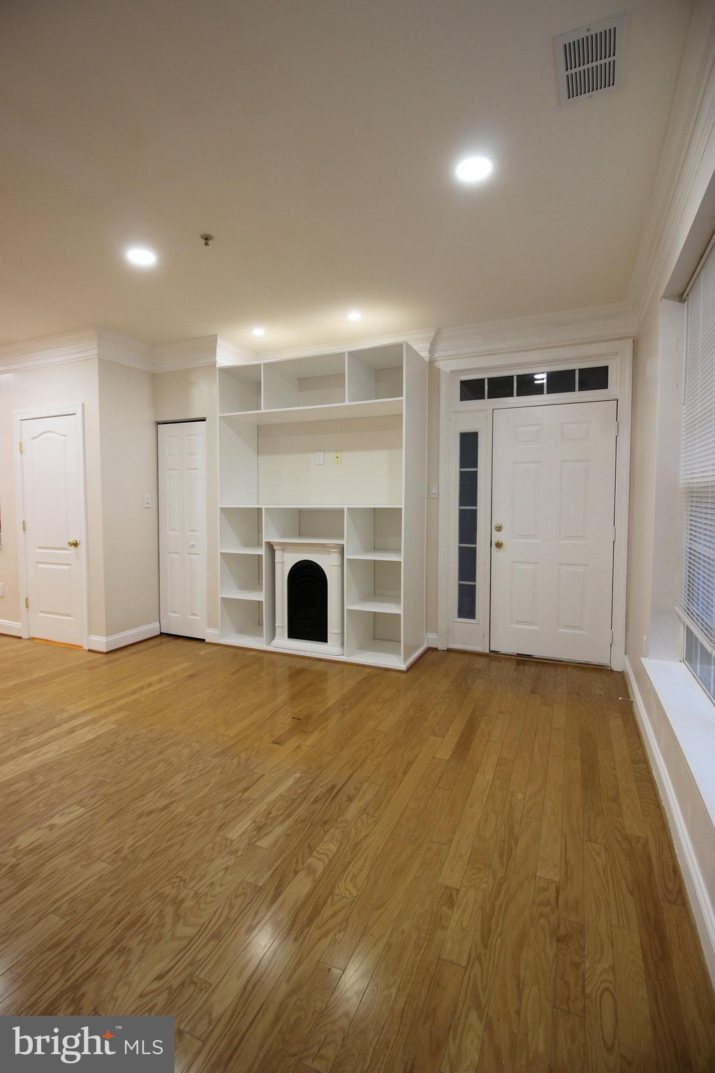 141 Chevy Chase Street, Unit 141 Gaithersburg, MD 20878 - Photo 3 of 32 an empty room with a fireplace and chandelier