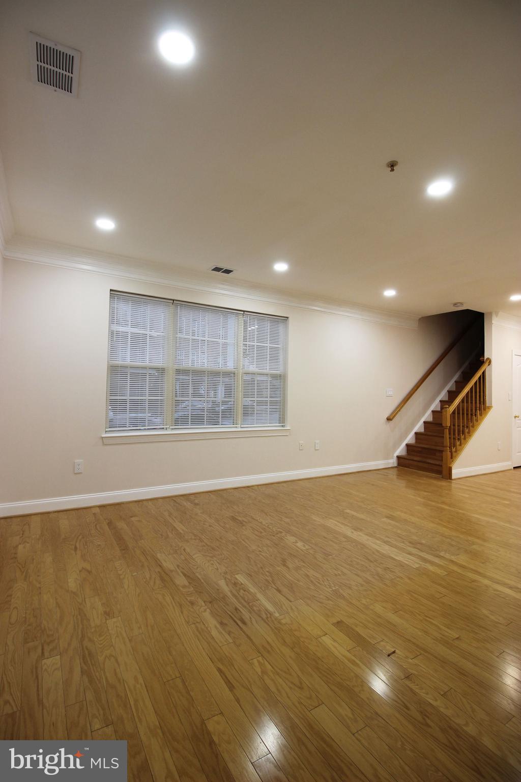 141 Chevy Chase Street, Unit 141 Gaithersburg, MD 20878 - Photo 4 of 32 a view of an empty room with wooden floor and a window
