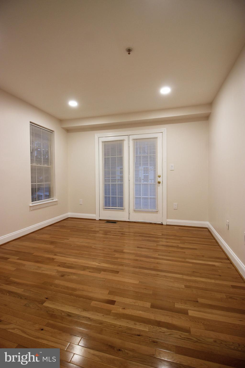 141 Chevy Chase Street, Unit 141 Gaithersburg, MD 20878 - Photo 9 of 32 a view of an empty room with wooden floor and a window