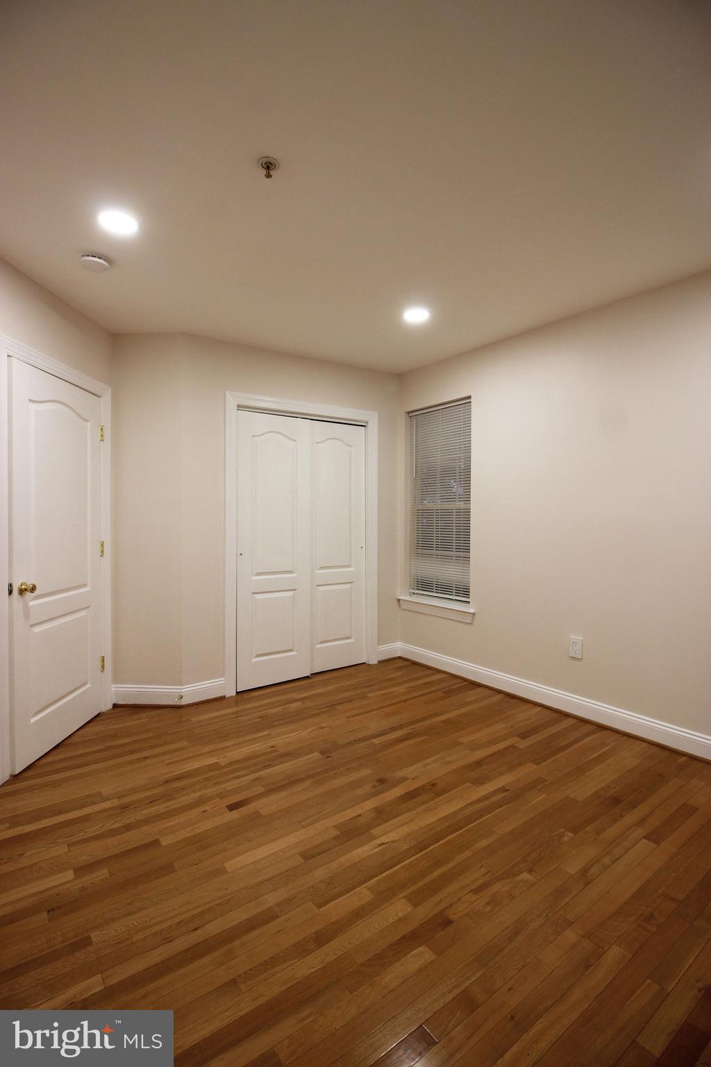 141 Chevy Chase Street, Unit 141 Gaithersburg, MD 20878 - Photo 10 of 32 a view of an empty room with wooden floor and a window