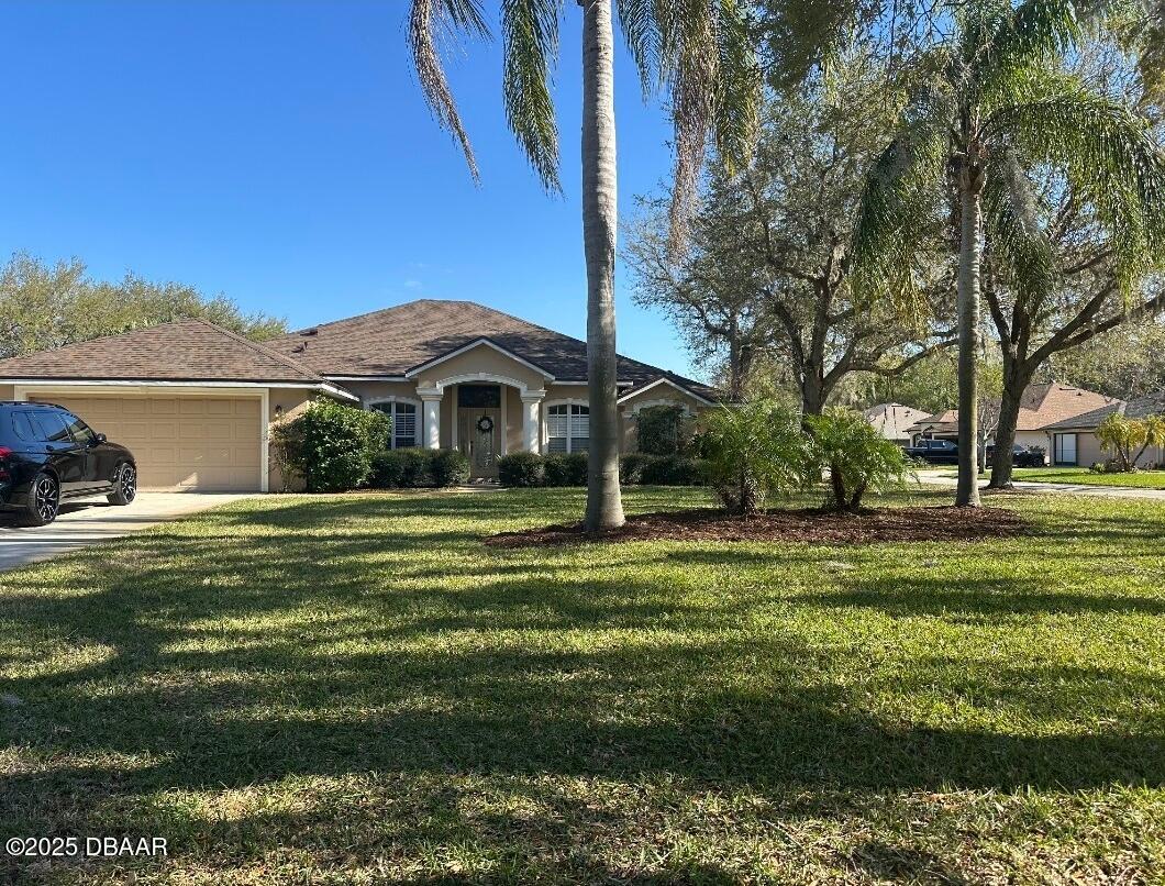 4 Waterbluff Drive Ormond Beach, FL 32174 - Photo 1 of 7 a front view of a house with a garden