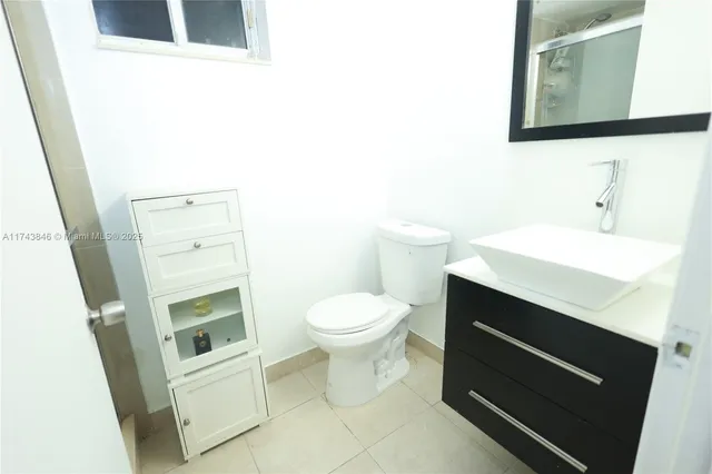 a bathroom with a sink a toilet and mirror