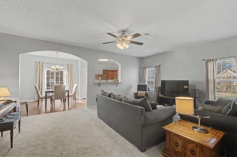 a living room with furniture a chandelier and a fireplace