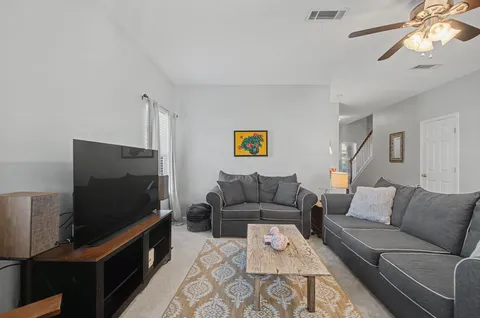 a living room with furniture and a chandelier