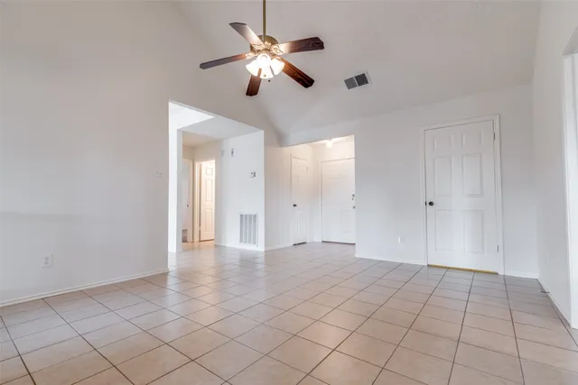 a view of an empty room with a chandelier fan
