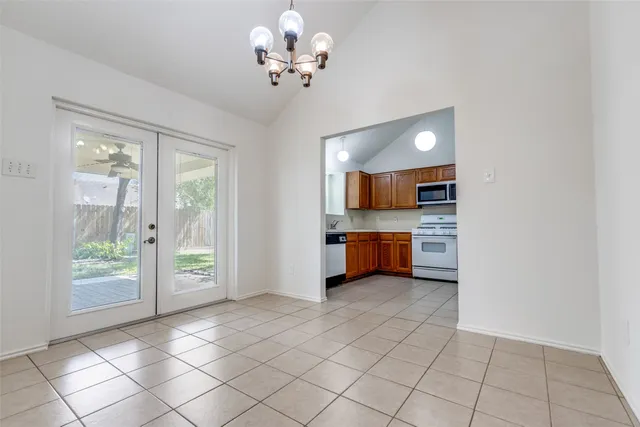 a large white kitchen with a sink and dishwasher a stove with wooden floor