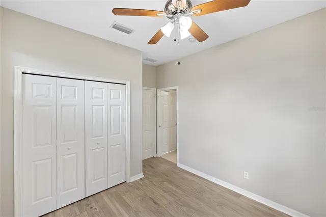 an empty room with windows and fan