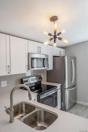 a kitchen with stainless steel appliances a sink cabinets and a refrigerator