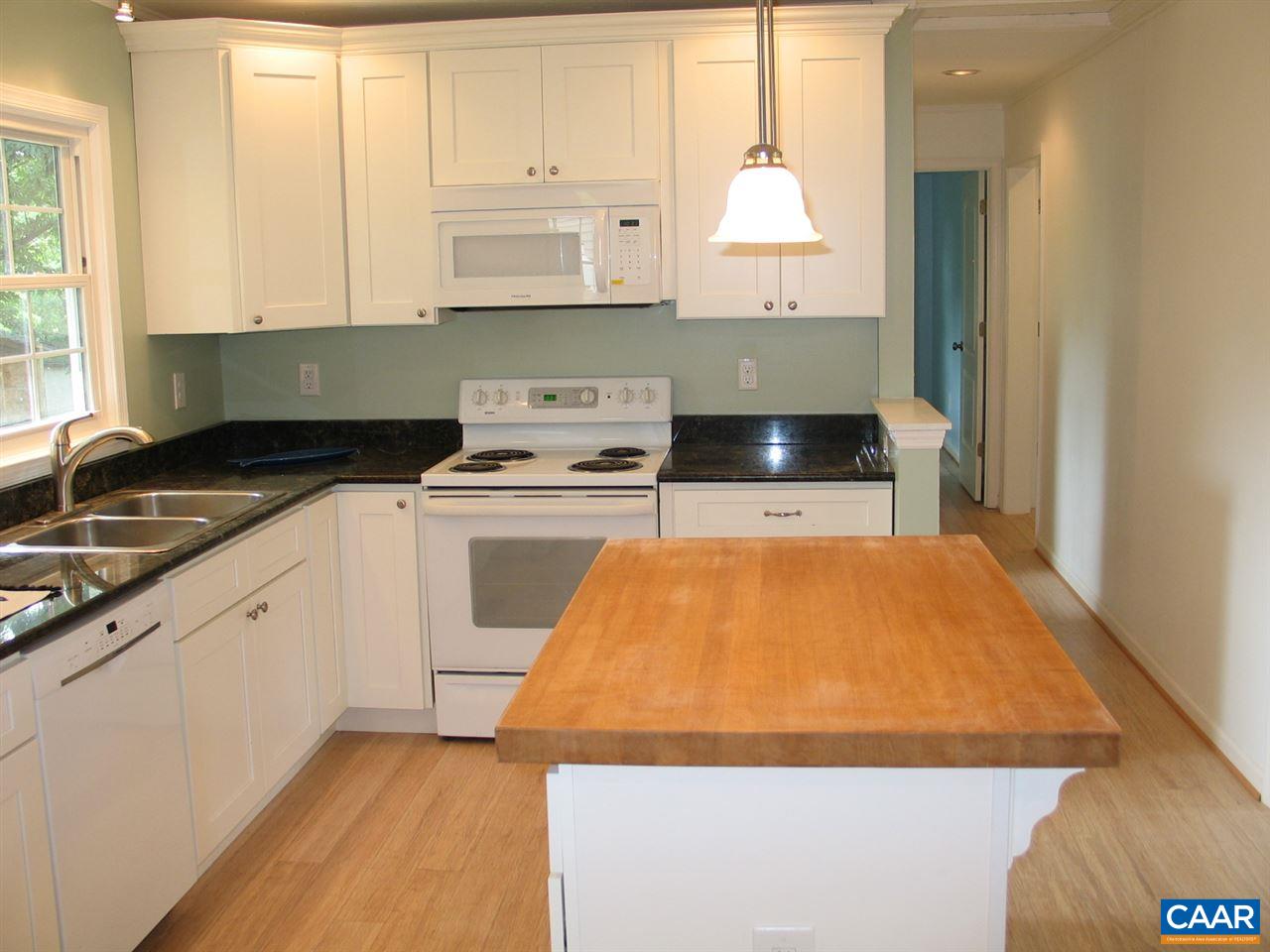 45 Holmes Run Road Stanardsville, VA 22973 - Photo 6 of 17 a kitchen with wooden cabinets and white appliances