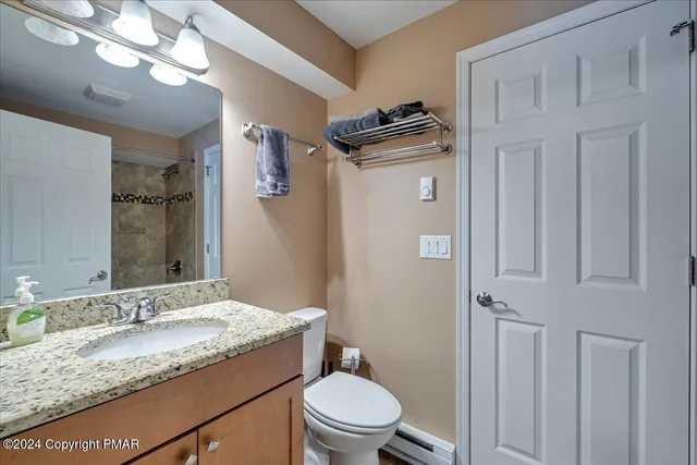 a bathroom with a granite countertop sink toilet and mirror