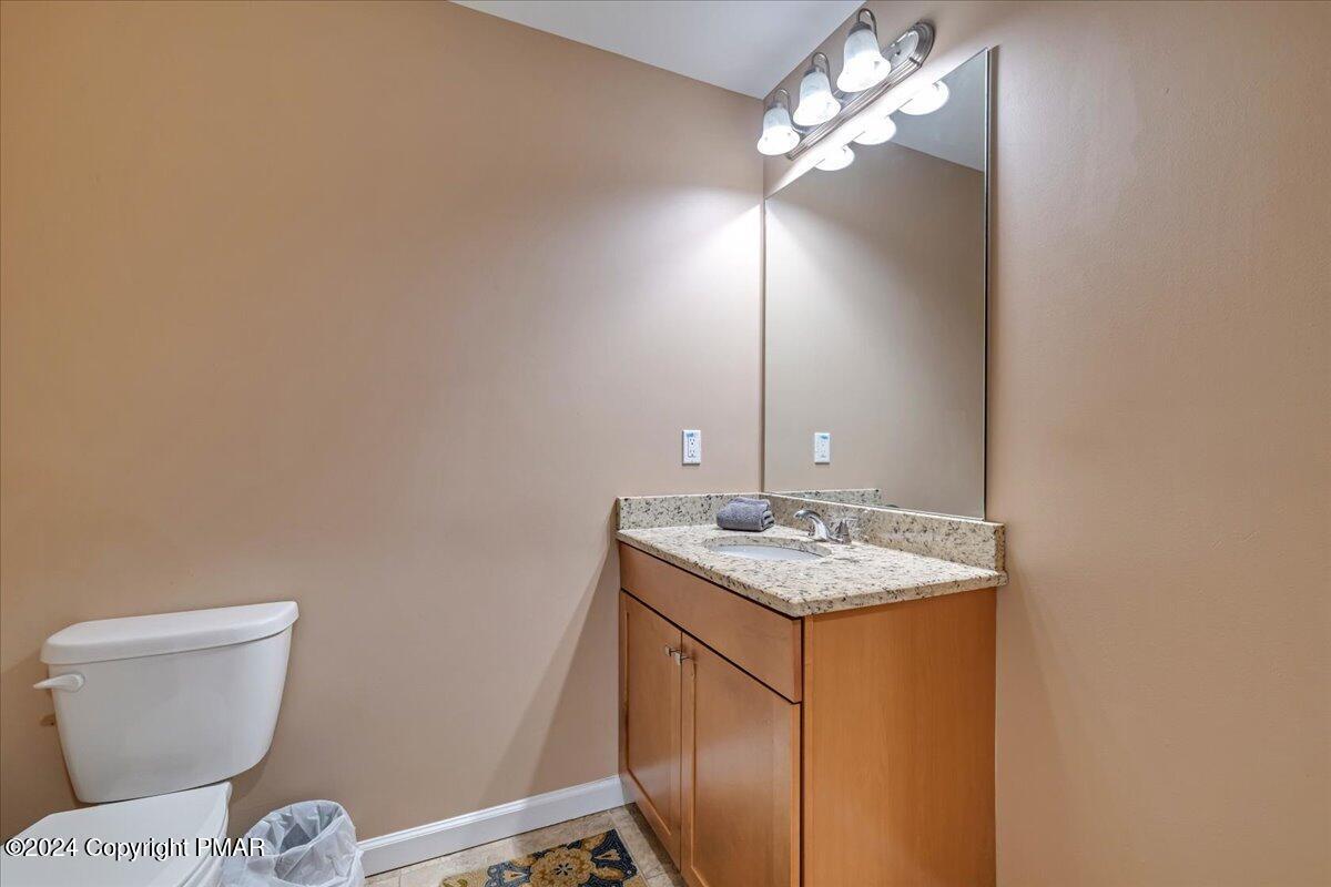 12 Beechwood Road Lake Harmony, PA 18624 - Photo 17 of 45 a bathroom with a granite countertop toilet a sink and a mirror