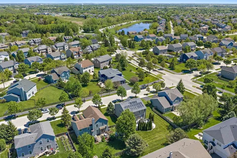 an aerial view of residential houses with outdoor space and trees