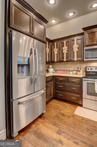 a kitchen with stainless steel appliances granite countertop a refrigerator and a sink