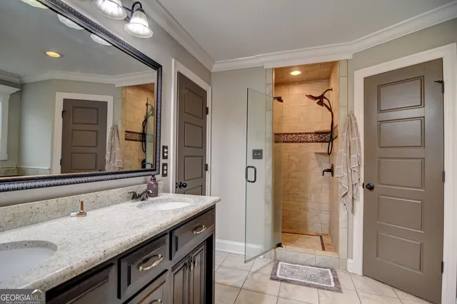 a bathroom with a granite countertop sink mirror and shower