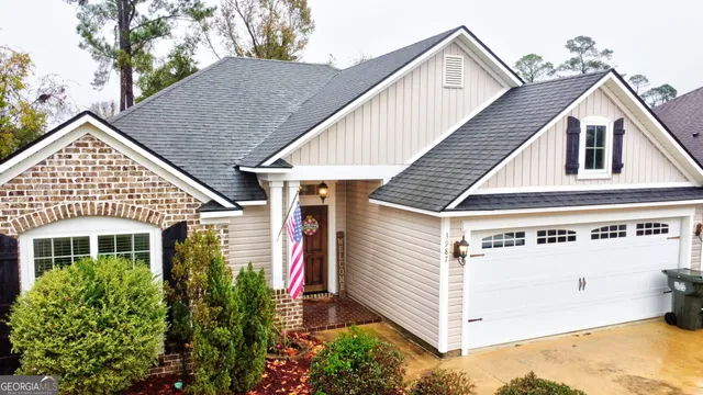 a view of a white house with a small yard and plants