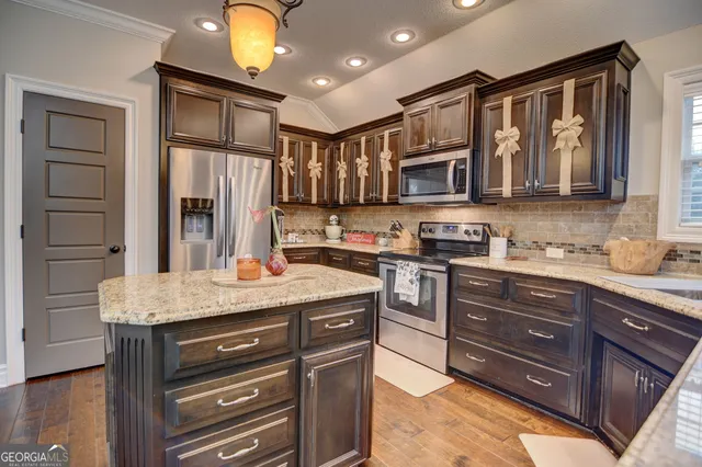 a kitchen with stainless steel appliances granite countertop a stove and cabinets