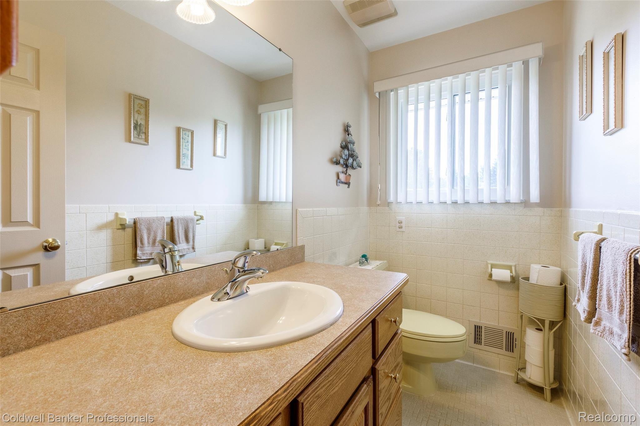 6945 Hubbard Road Clarkston, MI 48348 - Photo 17 of 22 1/2 bath has plenty of cabinet space and all ceramic tile