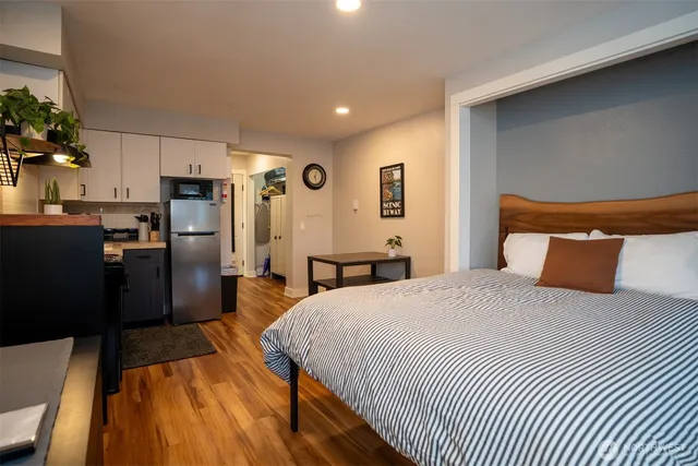 a spacious bedroom with a bed and a refrigerator