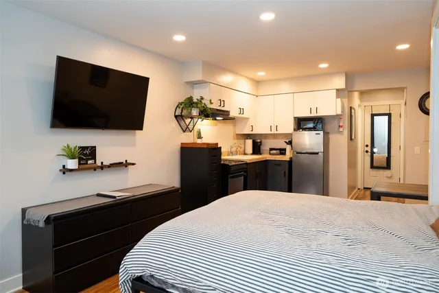 a kitchen view with stainless steel appliances kitchen island granite countertop a refrigerator and a stove top oven