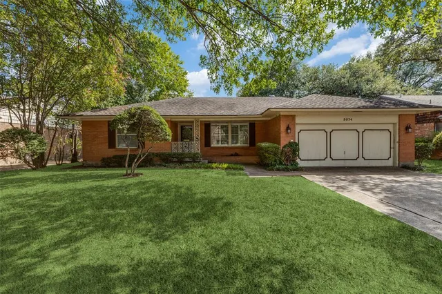 a view of a house with backyard and a tree