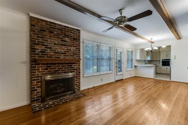 a view of empty room with wooden floor and fireplace