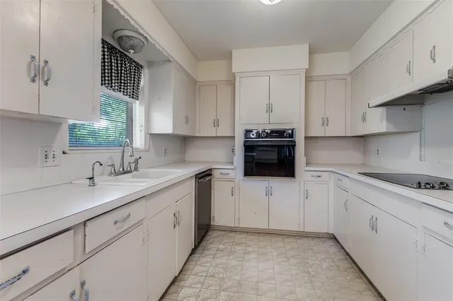 a kitchen with cabinets appliances a sink and a window