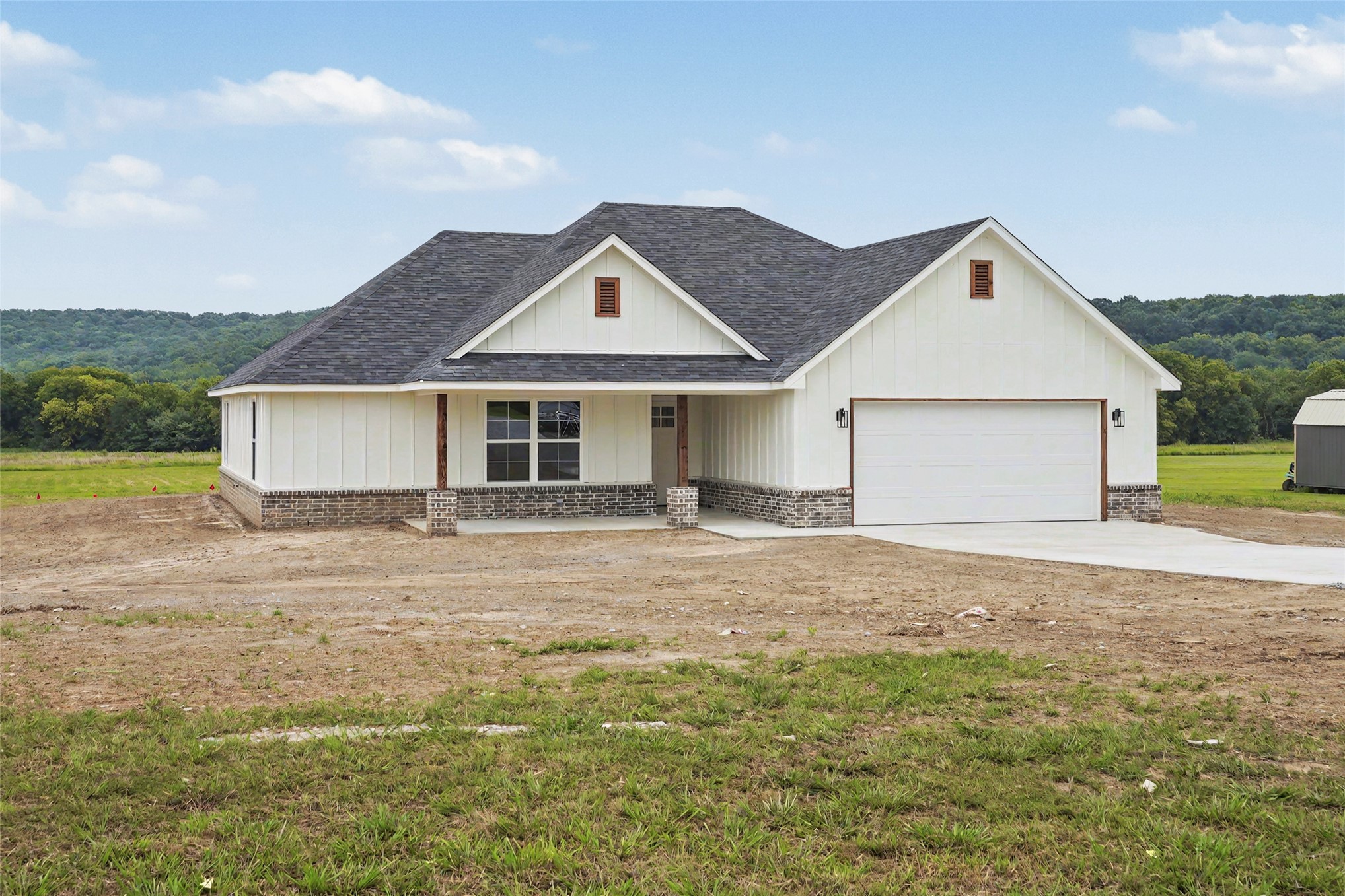 Single-story residence featuring white board-and-batten siding with a dark asphalt shingle roof