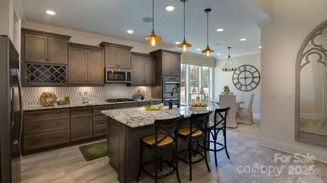 a kitchen with granite countertop a table chairs stove and cabinets