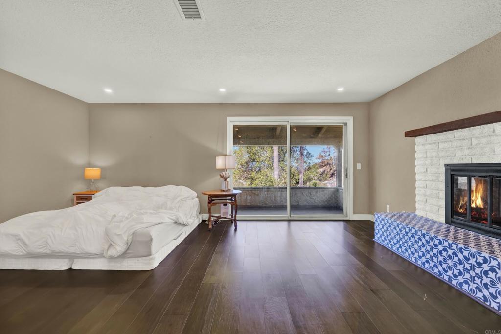29345 Wilkes Road Valley Center, CA 92082 - Photo 42 of 63 a bedroom with a bed and wooden floor