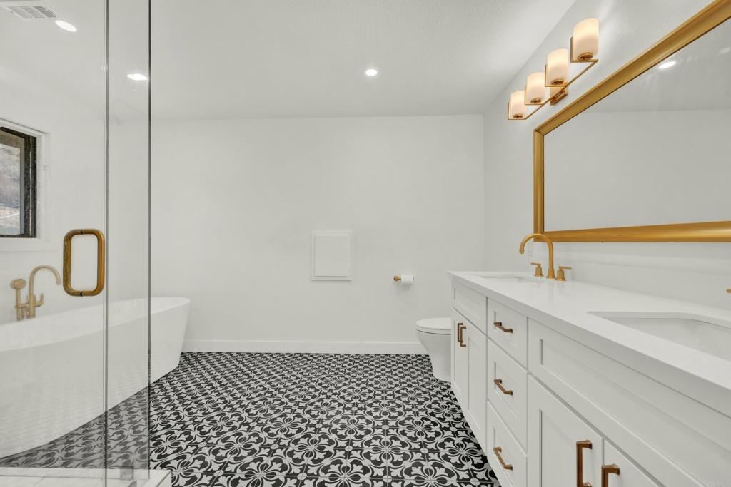 29345 Wilkes Road Valley Center, CA 92082 - Photo 44 of 63 a bathroom with a double vanity sink a toilet and a mirror