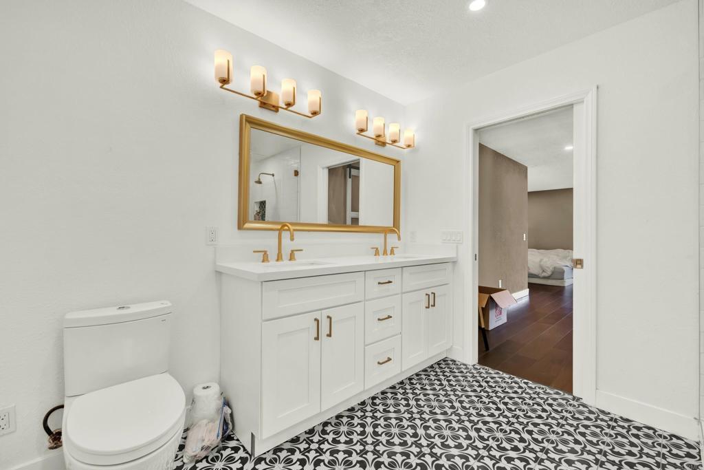 29345 Wilkes Road Valley Center, CA 92082 - Photo 46 of 63 a bathroom with a toilet a sink a mirror and vanity