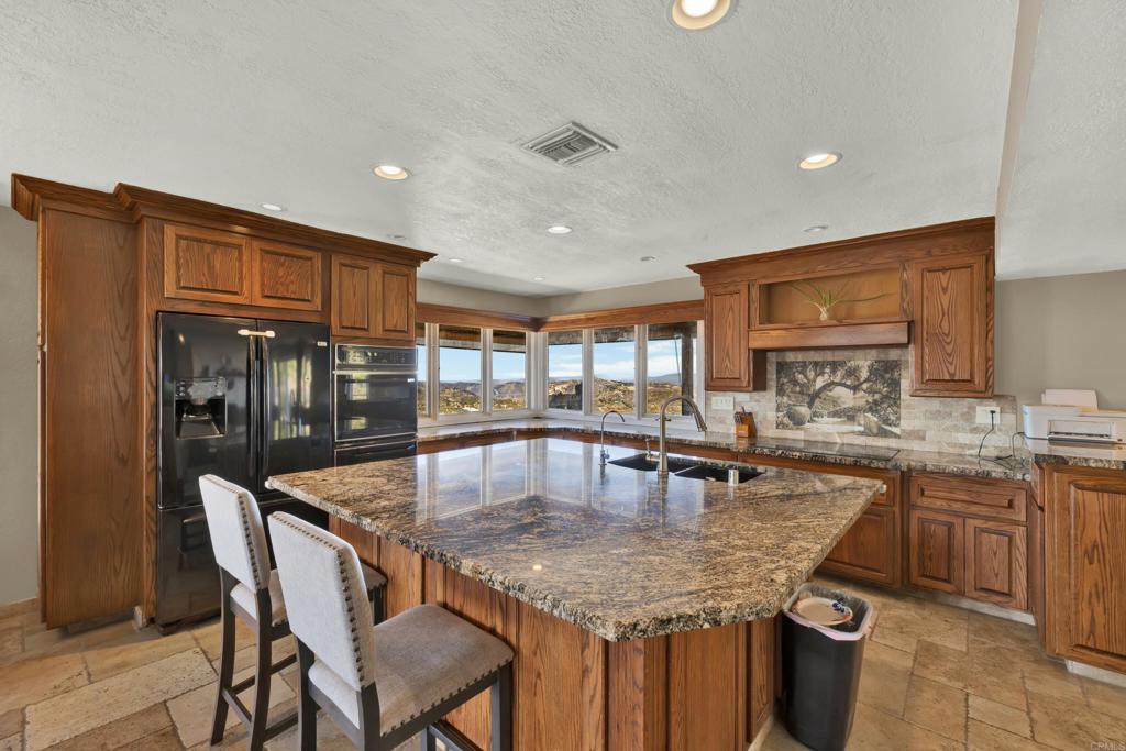 29345 Wilkes Road Valley Center, CA 92082 - Photo 56 of 63 a kitchen with granite countertop kitchen island stainless steel appliances a sink a counter top space and cabinets