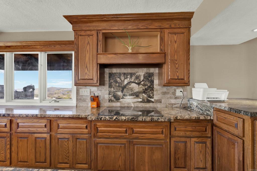 29345 Wilkes Road Valley Center, CA 92082 - Photo 58 of 63 a kitchen with granite countertop a sink and cabinets