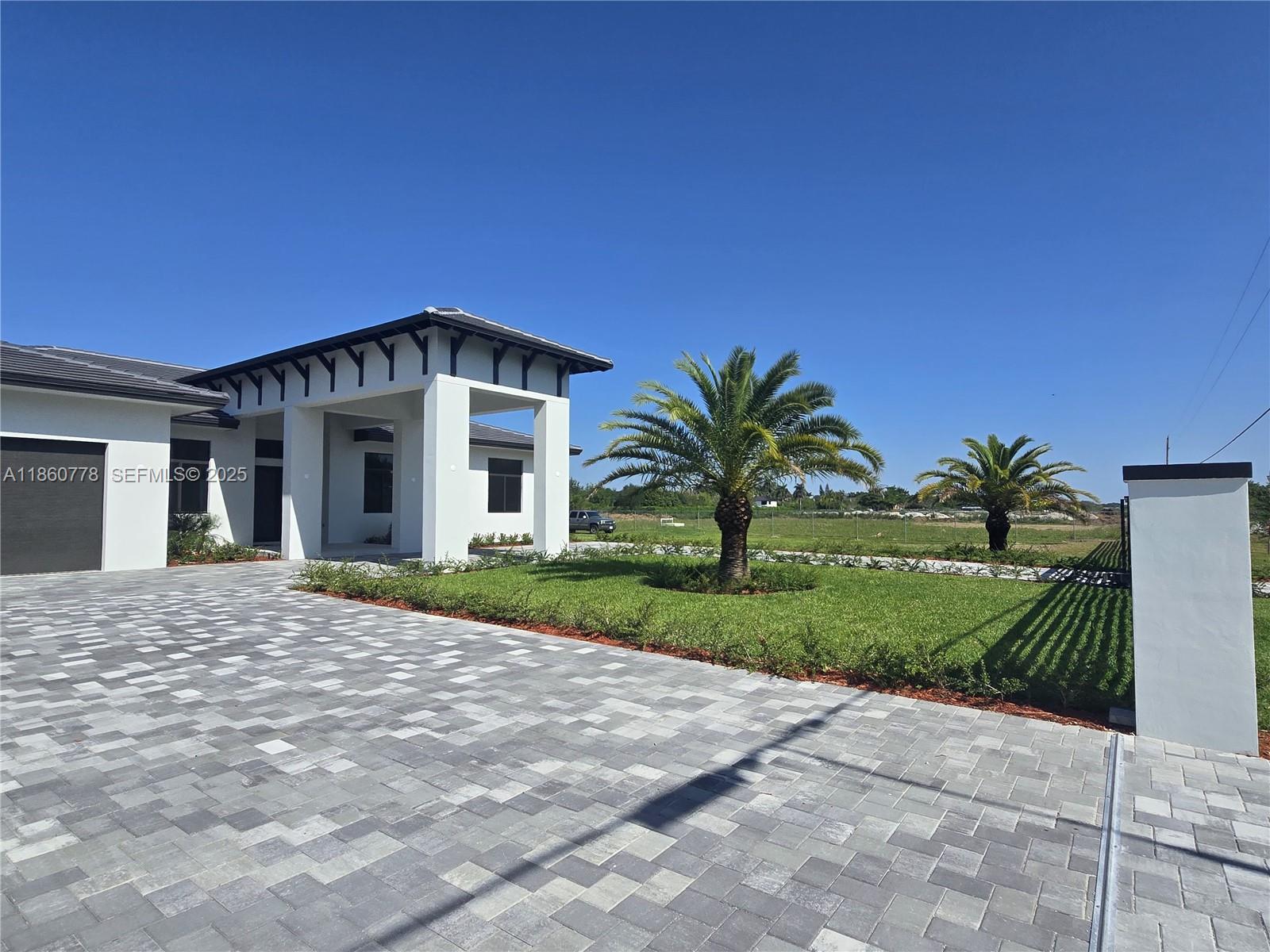 23840 Southwest 209th Place Homestead, FL 33031 - Photo 18 of 89 a front view of a house with a yard and garage